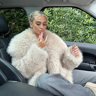 Trumpa dirbtinės pūkinės striukė su dideliu apykakle.