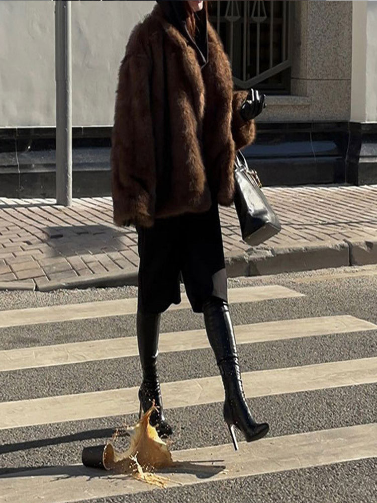 Dirbtinės odos paltas su polo apykakle ir vienspalve spalva.