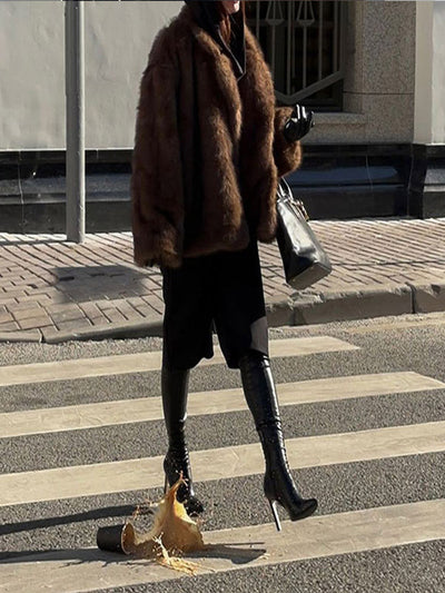 Dirbtinės odos paltas su polo apykakle ir vienspalve spalva.