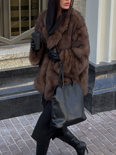 Dirbtinės odos paltas su polo apykakle ir vienspalve spalva.